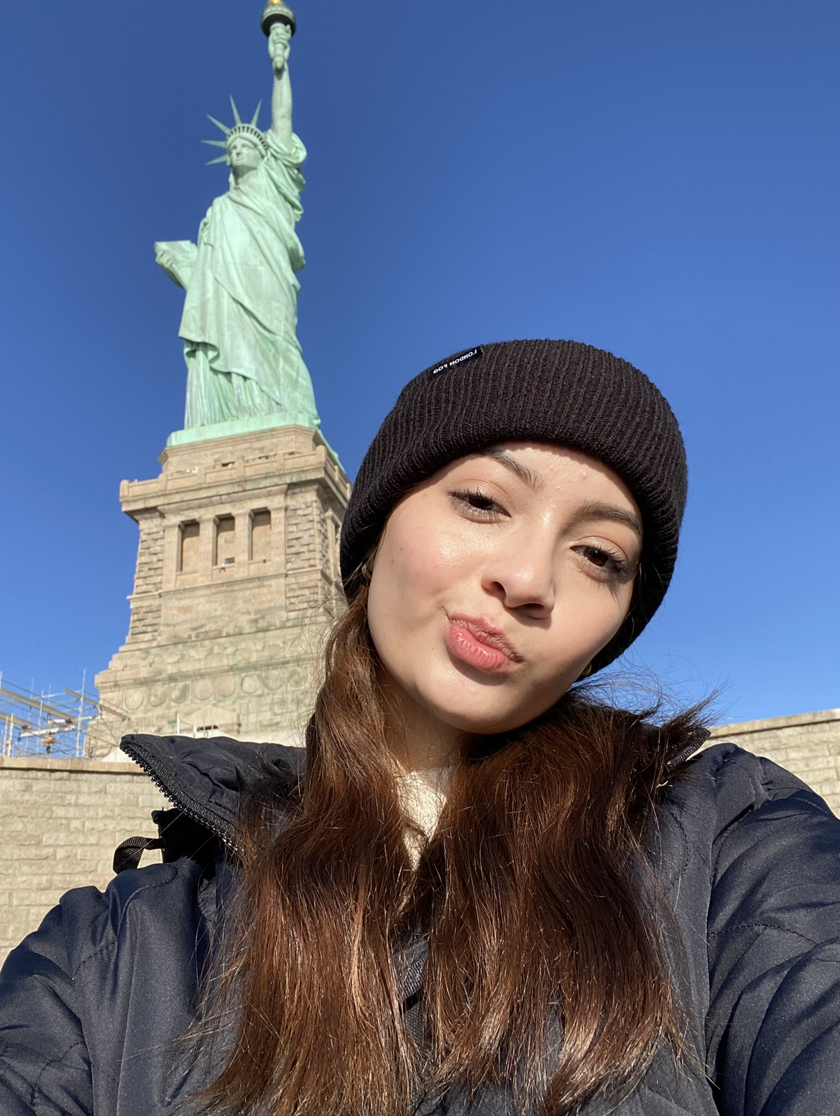 This is a photo of Lesly in New York City infron ot the Statue of Liberty
